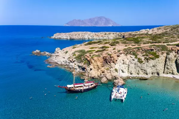 Drone shot of two boats and the sea on a catamaran daily excursion on the island of Milos, Greece