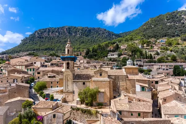 Drone shot: St. Bartholomew church and the well-preserved old town of Valldemossa, Mallorca