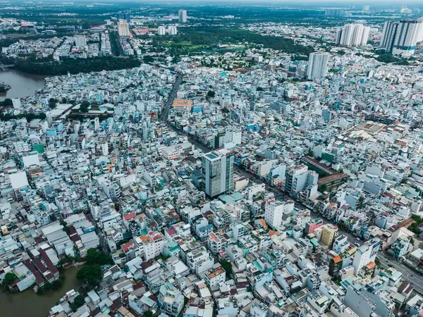 Dronenaufnahme von Distrikt 8 mit vielen Häusern, Wohngegenden und Straßen mit Nha Be Stadtbezirk im Hintergrund in Ho Chi Minh Stadt, Vietnam