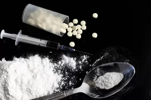 Drug syringe and cooked heroin on spoon