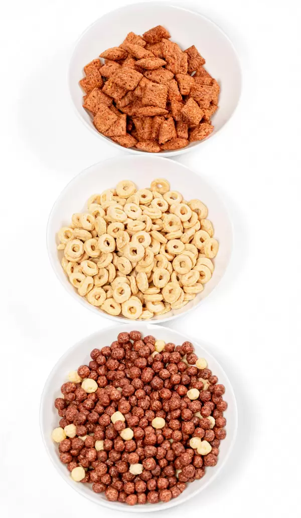 Dry breakfast cereals in bowls on white