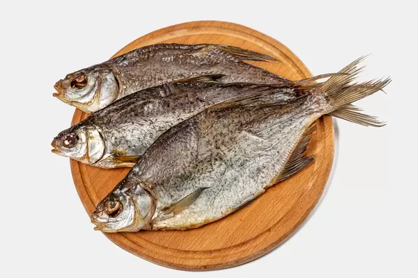 Dry fish on wooden background, top view