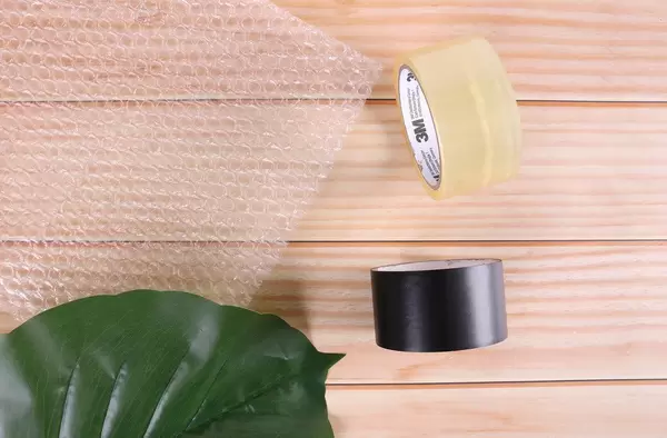 Duct tapes and bubble wrap on wooden table