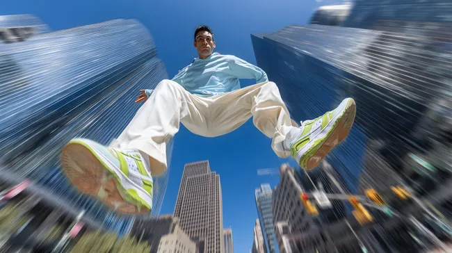 Dynamischer Mann springt zwischen Hochhäusern in der Stadt