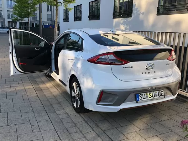 E-Car by Hyundai ionic electric in white with open driver's door in a parking spot