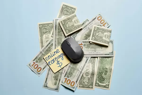 Earning online concept - pc mouse and usd banknotes
