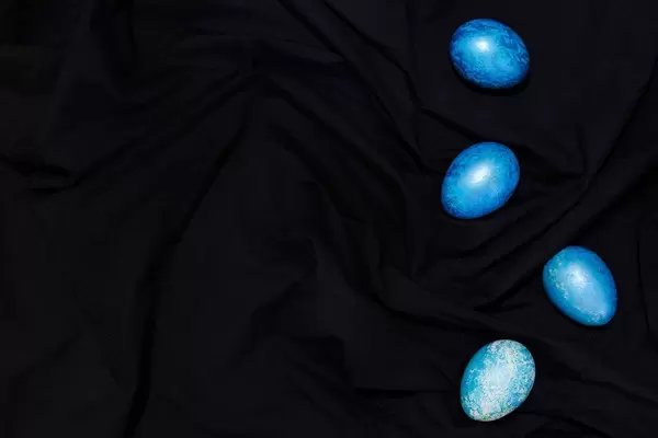 Easter concept. Easter festive eggs painted in trendy classic blue color on the dark textile (Flip 2020)