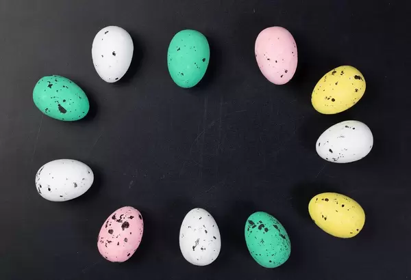 Easter eggs laying in circle on black background