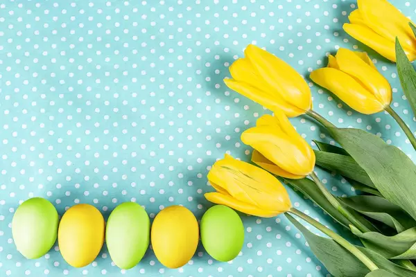Easter eggs with yellow tulips on blue background (Flip 2020)