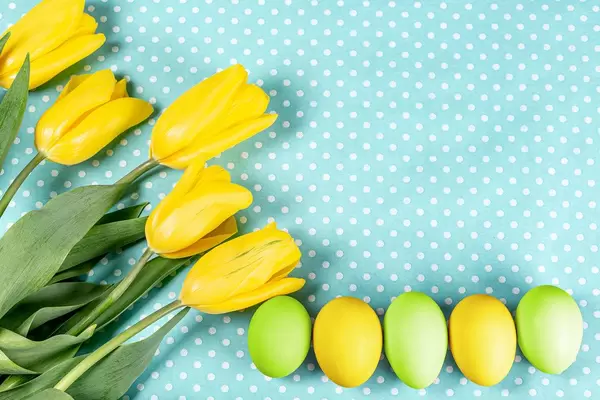 Easter-eggs-with-yellow-tulips-on-blue-background.jpg