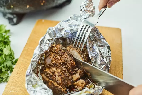 Eating deliciously fried on foil chicken meat