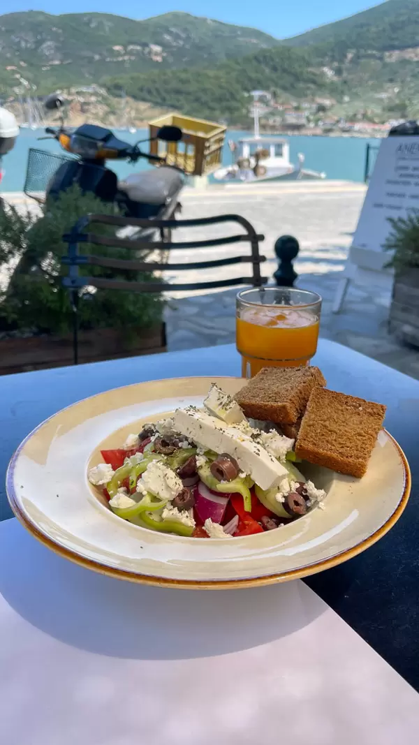 Eating vegetarian while on holiday on Skopelos, Greece: plate with feta, tomatoes, green peppers, onions (Greek Salad)