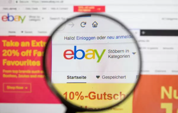Ebay-Logo am PC-Monitor, durch eine Lupe fotografiert