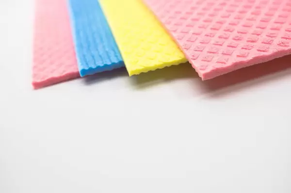 Ecken von farbigen Schwammtüchern auf weißem Hintergrund