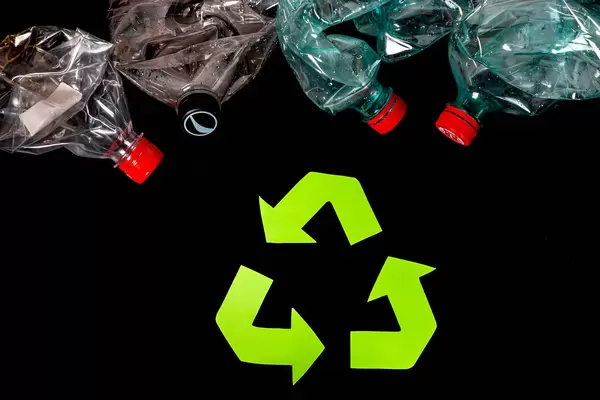Eco concept with recycling symbol on dark background, top view