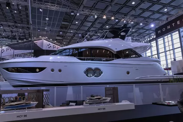 Edle Luxusyacht in Messehalle, davor Modelle von Yachten von Monte Carlo Yachts