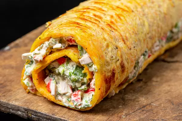 Egg roll with crab meat, herbs and cheese, close-up