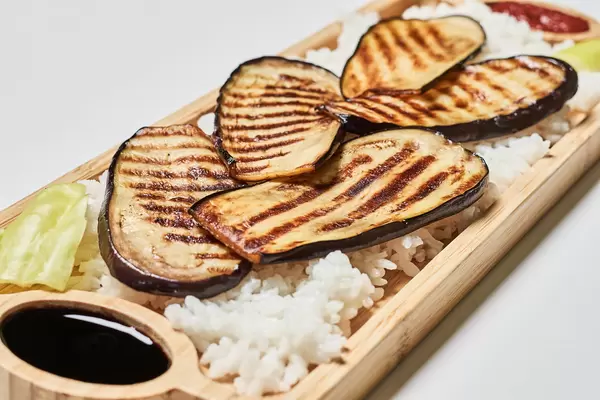 Eggplant grilled with rice on a wooden plate