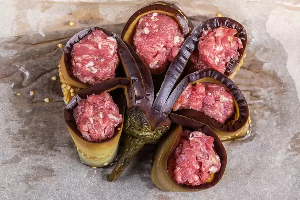 Eggplant stuffed with minced meat on parchment is prepared for baking