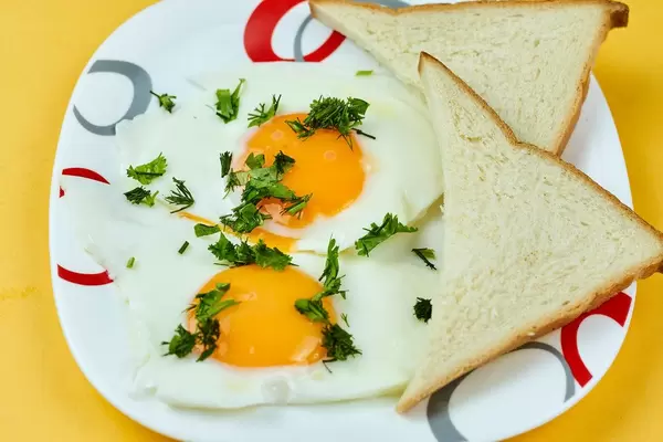 Eggs and sandwich toasts on yellow background