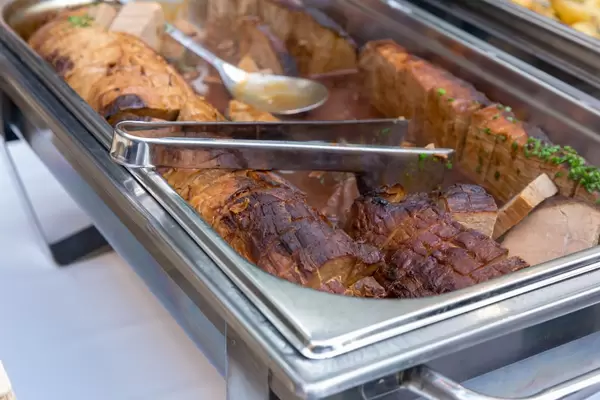 Eifeler Rinderbraten in einem Warmhaltebehälter mit Zange an einem Buffett