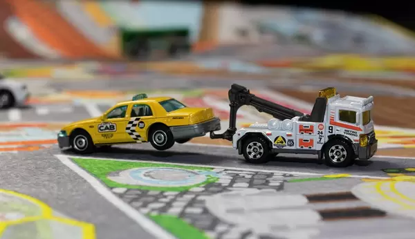 Ein Abschleppwagen schleppt ein kaputtes Taxi ab - Modelauto