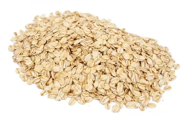 Ein Berg von trockenen Haferflocken auf einer weißen Oberfläche