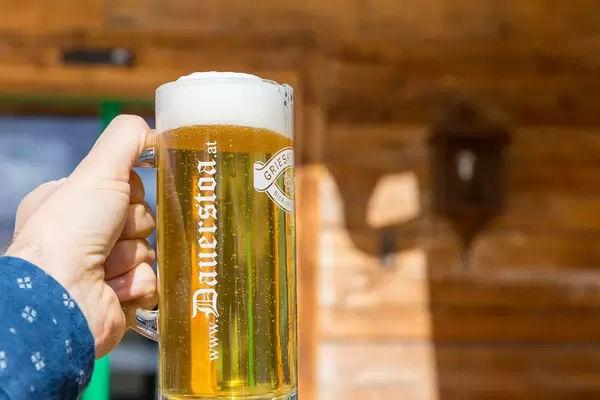 Ein Bier vom Fass bei der Dauerstoa Alm in Alpbach. Nahaufnahme vor hölzernem Hintergrund