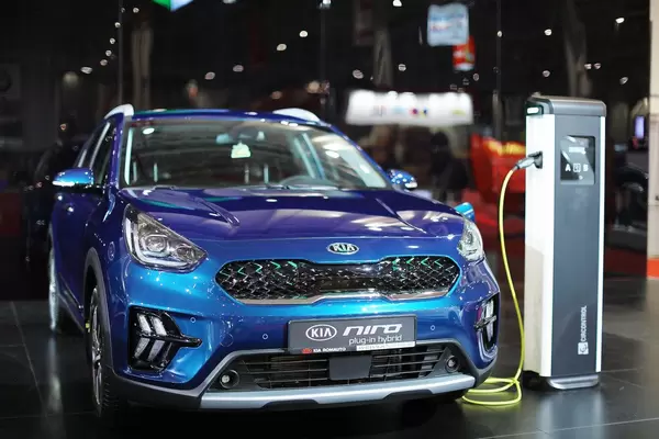 Ein blaues KIA Niro Plug-In Hybrid wird bei einer Ladestation auf der Automesse in Bukarest geladen