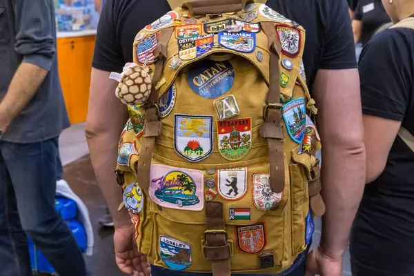 Ein Fan auf der Spielemesse trägt ein Rucksack mit vielen verschiedenen Patches