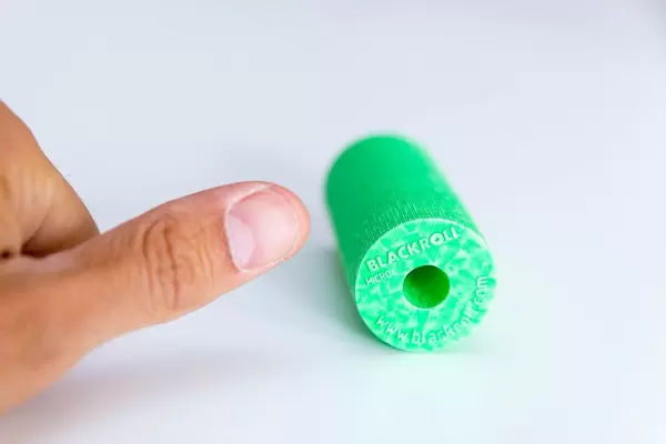 Ein Finger neben der Faszienrolle Blackroll, für Regenerationsübungen und Massage