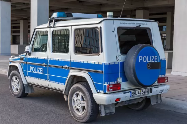 Ein großes Polizeiauto geparkt vor dem neueröffneten Flughafen BER in Berlin