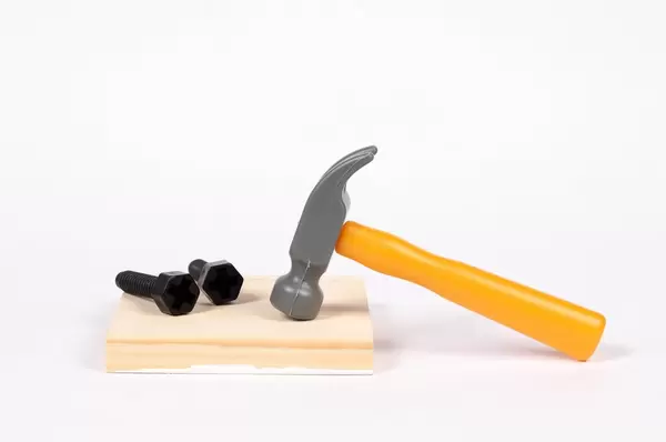 Ein Hammer und Schrauben auf einem Brett - Plastik Werkzeug