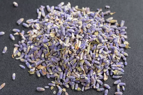 Ein Haufen getrockneter Lavendel-Tee auf schwarzem Hintergrund
