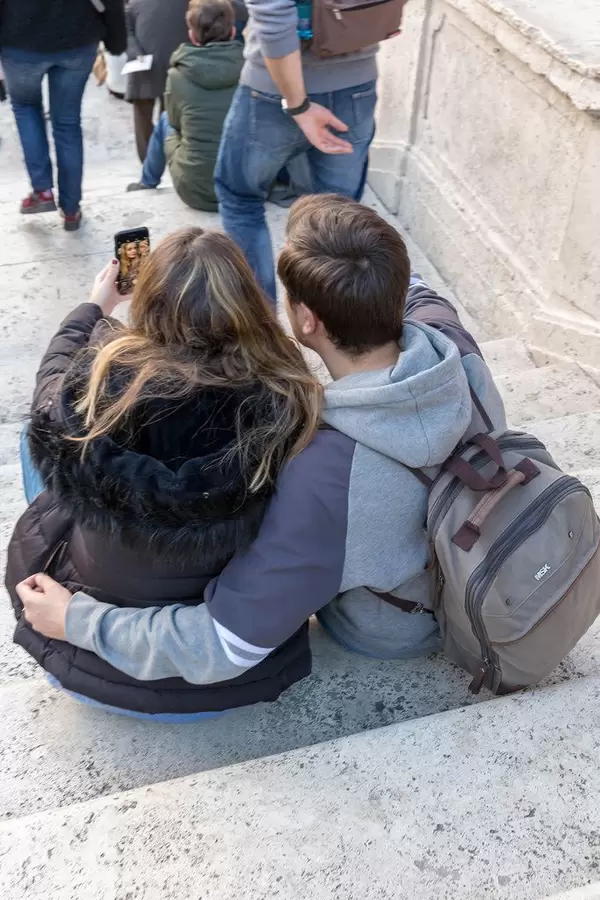 Ein junges Pärchen macht ein Selfie auf den Spanischen Treppen auf dem Piazza di Spagna - der weltbrühmte Spanische Platz