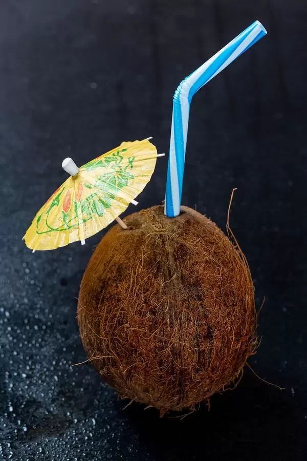 Ein Kokosnuss-Cocktail mit Schirm und Strohhalm