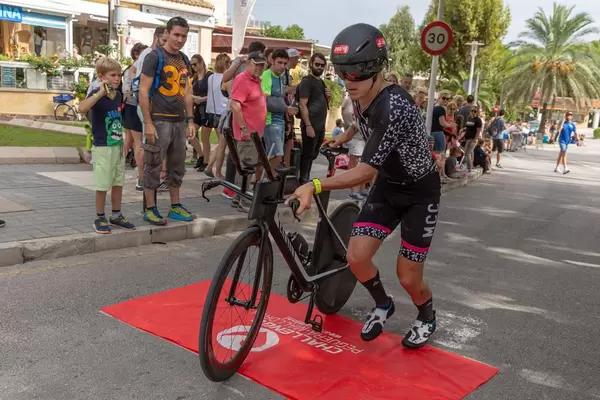 Ein Mann bei einem Triathlon wechselt von Lauf auf Radfahren