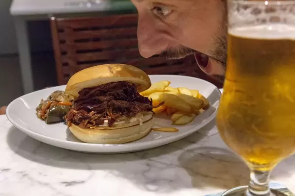 Ein Mann beißt vor Heißhunger in einen Pulled-Beef Burger