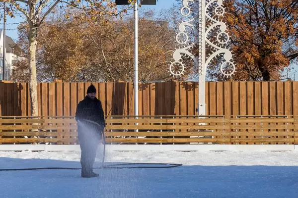 Ein Mann bereitet die Schlittschuhlaufbahn vor