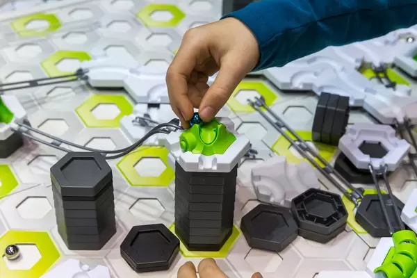 Ein Mann legt eine Murmel auf das Gravitrax