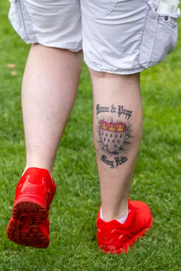 Ein Mann mit Tattoo Ming Hätz am Unterschenkel