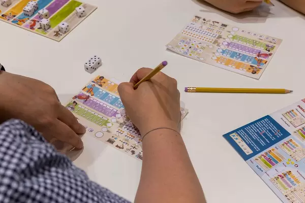 Ein Mann spiel Corinth von Sebastien Paukhon und füllt den Spielbogen aus