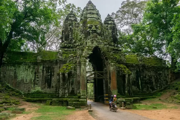 Ein Motorrad fährt durch das Victory Gate beim Angkor Thom in Siem Reap
