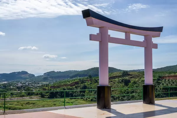 Ein nachgebautes Japanisches Torii mit Aussicht auf Kaffee- und Teeplantagen auf der Terasse des Me Linh Cafes in Da Lat, Vietnam
