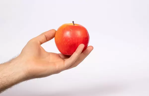 Ein Roter Apfel in einer Hand gehalten w