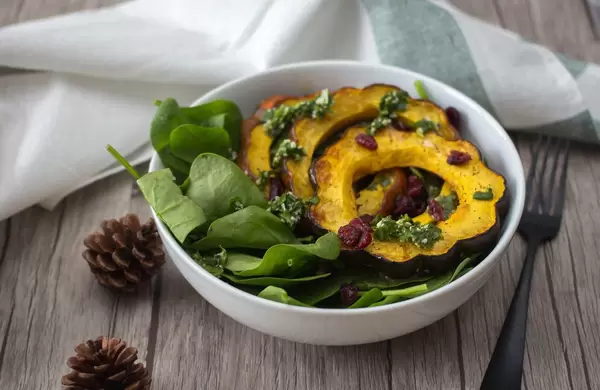Ein Salat aus Speisekürbis mit Spinat und Cranberries in einer Schüssel