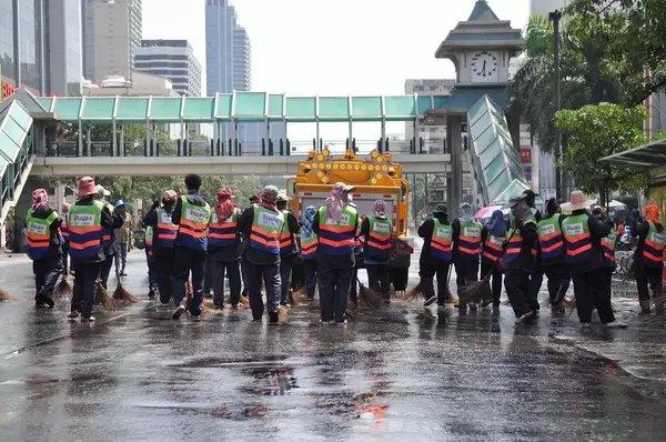 Ein Schar von Arbeitern reinigt eine Straße - Thailand