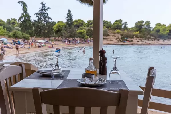 Ein schicker, gedeckter Tisch für Zwei, im Restaurant "Taverne Hinitsa", mit Meerblick im Urlaubsort Porto Heli, Griechenland