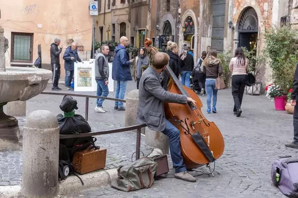 Ein Straßenmusiker spielt auf dem Kontrabass auf einem Platz in Rkm