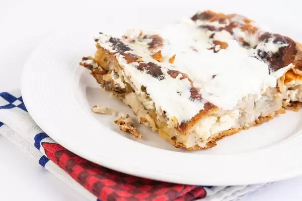 Ein Stück Käsekuchen auf einem weißen Teller serviert